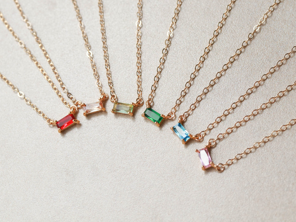 A group of customized gemstone baguette necklaces from Tom Design.